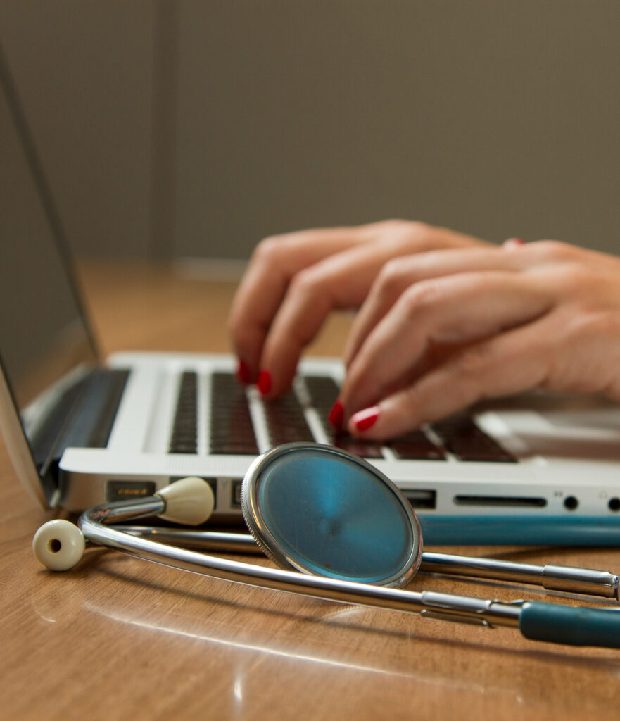 Pilier parcours médical. Médecin prenant des notes sur son ordinateur. Stéthoscope au premier plan.